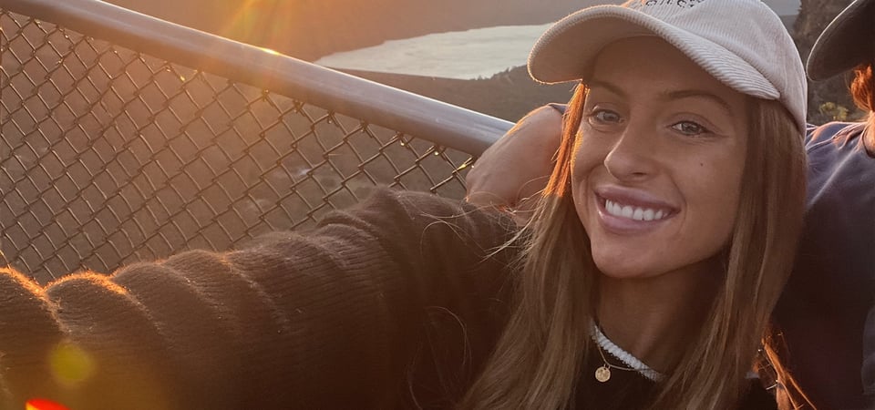 A woman wearing a hat takes a selfie