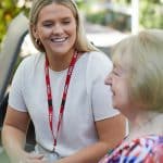 Volunteer talking wiht elder and smiling